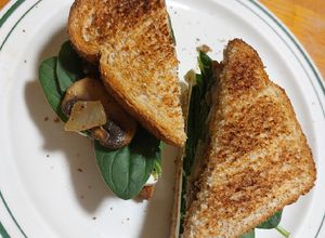 Una foto de Sandwich de queso con espinacas y champiñones