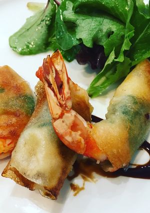 Una foto de Langostinos crocantes con albahaca fresca y aderezo de maracuyá y ensalada verde mixta