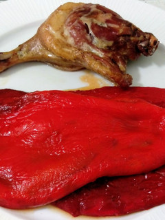 Una foto de Muslo de pato confitado y pimientos asados