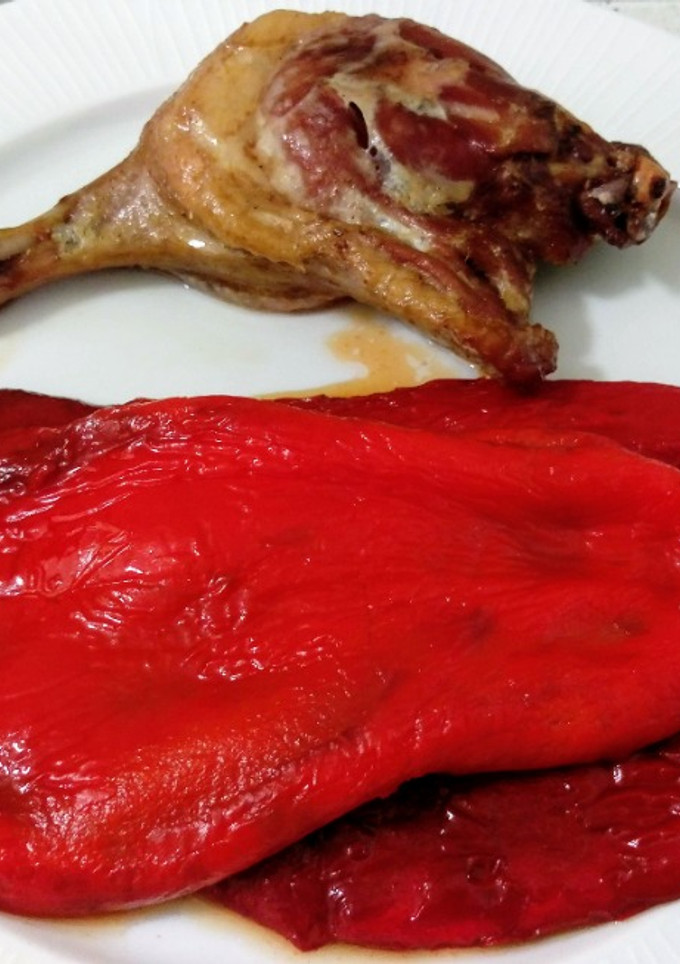 Una foto de Muslo de pato confitado y pimientos asados