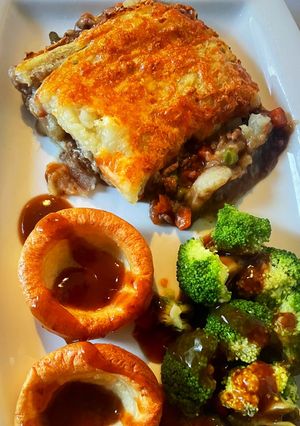 A picture of Shepards pie with a crispy cheese topping 😍 served with Yorkshire and broccoli 👌🏻🤤.
