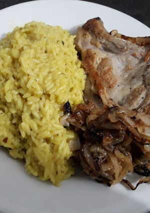Una foto de Costeleta de cerdo con arroz y cebollas caramelizada