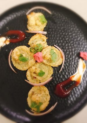 A picture of Parmesan chilli duchess potatoes swirl with red pepper sauce.