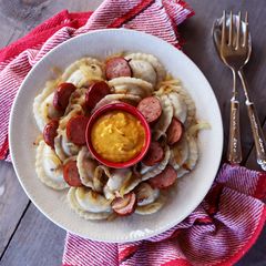 A picture of Perogies with Kielbasa, Onion, and Hot Mustard.