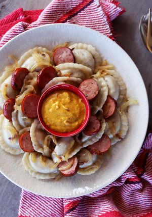 A picture of Perogies with Kielbasa, Onion, and Hot Mustard.