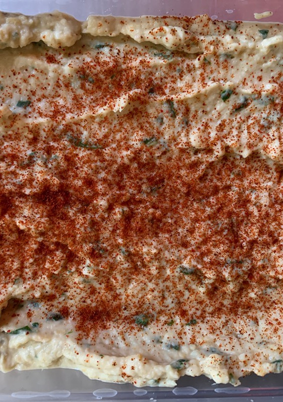 Una foto de Hummus con rúcula