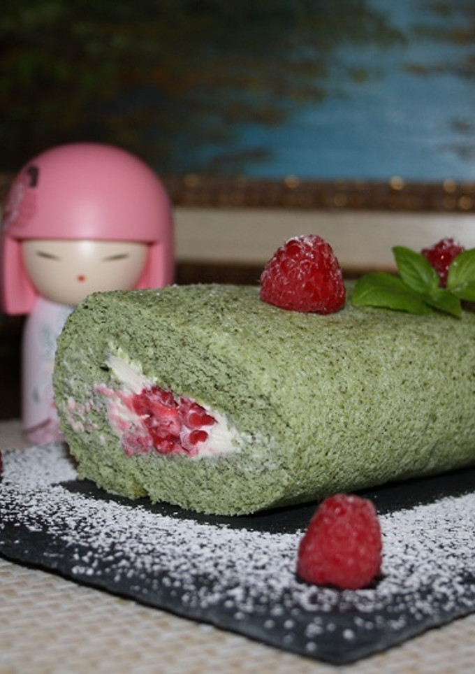 Una foto de Rollo de té matcha, relleno de crema de queso y frambuesas