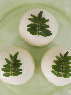 A picture of Wagashi "Komugi-Manju" with a Fresh Herb.