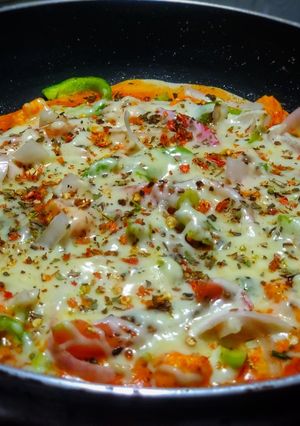 A picture of Veg delite pizza on tawa with homemade pizza base.