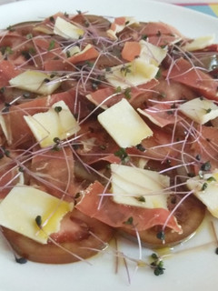 Una foto de Ensalada de kumato con jamón, grana padano y brotes