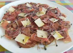 Una foto de Ensalada de kumato con jamón, grana padano y brotes