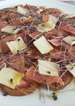 Una foto de Ensalada de kumato con jamón, grana padano y brotes