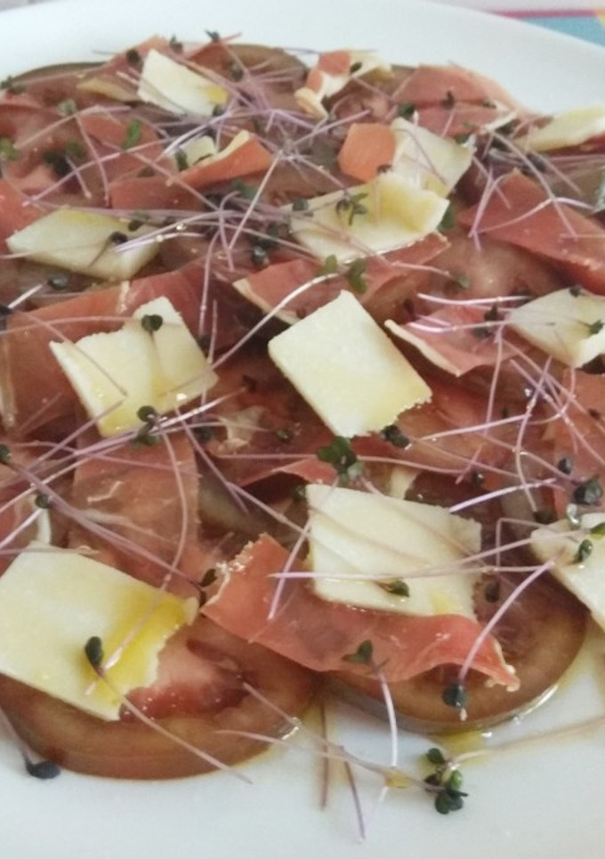 Una foto de Ensalada de kumato con jamón, grana padano y brotes