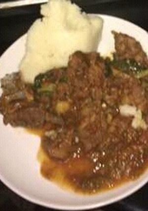 A picture of Beef stew served with Ugali.