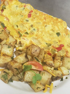 Una foto de Tortilla de huevo rellena con tres carnes + vegetales, papas asada