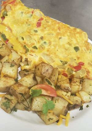 Una foto de Tortilla de huevo rellena con tres carnes + vegetales, papas asada