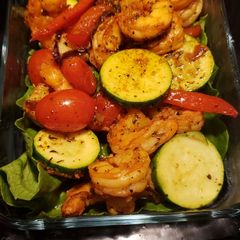 A picture of Shrimp zucchini on a bed of romaine lettuce.