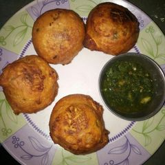 A picture of Aalu bonda with green chutney.