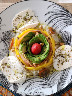 Una foto de Ensalada de aguacate, mango, salmón, frutos secos y queso fresco