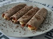 Una foto de crepes con fresas y plátano