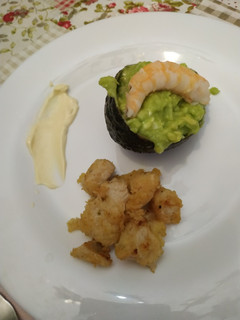 Una foto de Aguacate relleno acompañado de lagrimitas de pollo caseras
