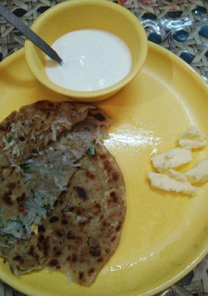 A picture of Muli de parathe with batter and dahi.