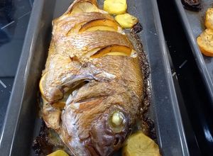 Una foto de Pargo Rosado con guarnición de patatas y cebollas horneadas
