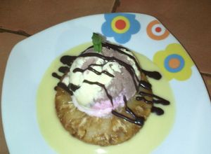 Una foto de Piñas flambeadas en espejo de salsa inglesa y helado.