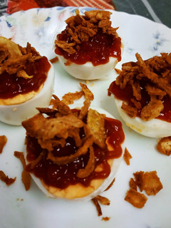 Una foto de Pinchos de huevo cocido con ketchup y cebolla frita crujiente