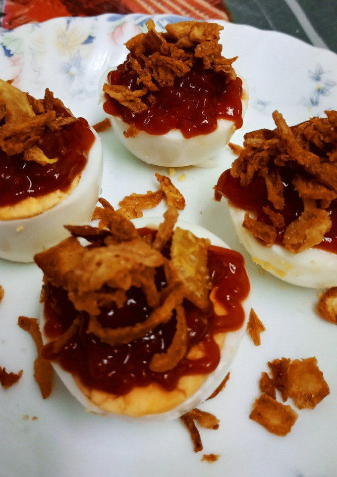 Una foto de Pinchos de huevo cocido con ketchup y cebolla frita crujiente