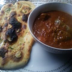 A picture of Beef Madras with garlic naan bread.