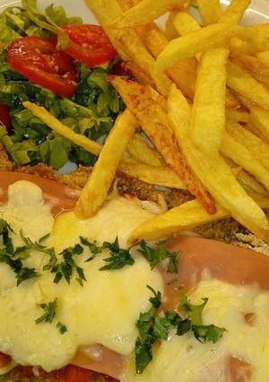 Una foto de Napolitana con papas y ensalada