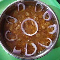 A picture of Kabuli chanawith onion rings.