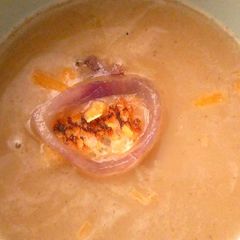A picture of Onion soup with cheddar cheese.