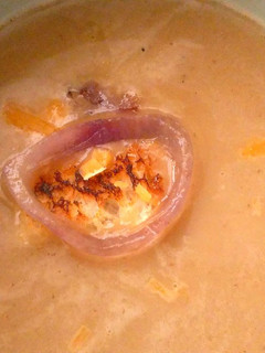 A picture of Onion soup with cheddar cheese.