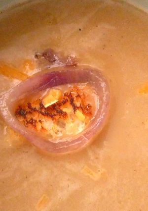 A picture of Onion soup with cheddar cheese.