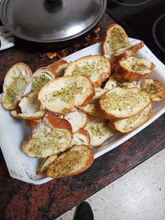 Una foto de Pan de pueblo tostado al horno con aceite de ajo y perejil