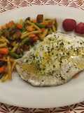 Filetes de rodaballo sobre una cama de verduras y al horno