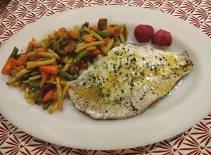 Una foto de Filetes de rodaballo sobre una cama de verduras y al horno