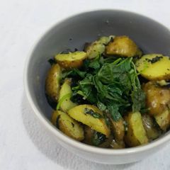 A picture of Sautéed baby potatoes with steamed spinach.