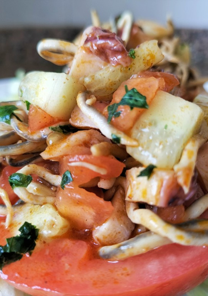 Una foto de Tomates rellenos de gulas y pulpo al pimentón