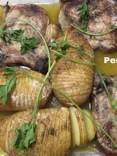 Una foto de Asado de chuletas de cerdo con patatas hasselback
