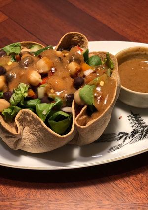 A picture of Tortilla Greens Chickpeas Salad Bowl with Refried Bean Dates dressing.
