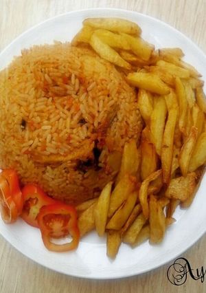 A picture of Jollofrice,with fried Irish potatoes and tomatoes.
