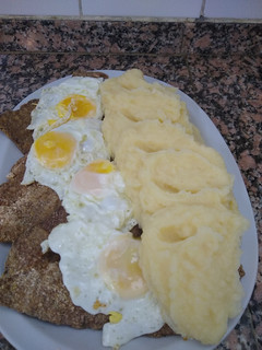Una foto de Milanesas a caballo con puré de papas cremoso