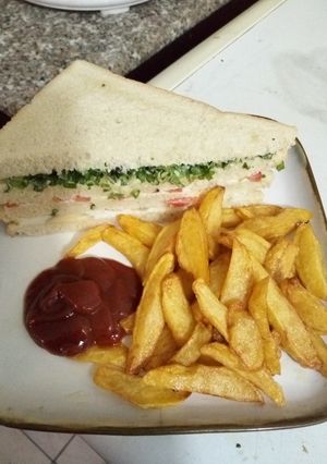 A picture of Vegetable Sandwich with Fried Irish Potato and Ketch up.