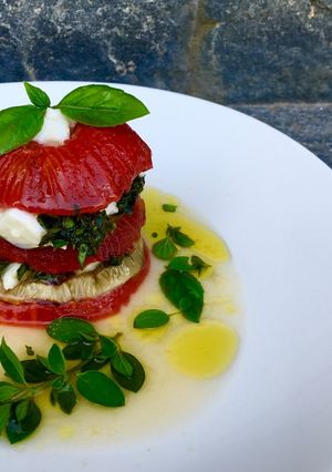 Une photo de Millefeuille de tomates confites, aubergines grillées au grill, mozzarella di bufala