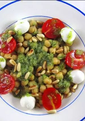 Una foto de Garbanzos con tomate, mozzarella, piñones y salsa pesto