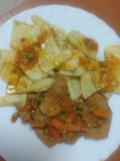 Una foto de Solomillo con zanahoria, guisantes y papas fritas al ajillo