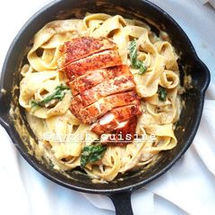 A picture of Chicken fettuccine pasta in white sauce.